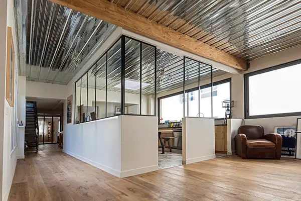 Photo du déchargement d'une vitre garde-corps deposée par une grue sur le toit d'un immeuble